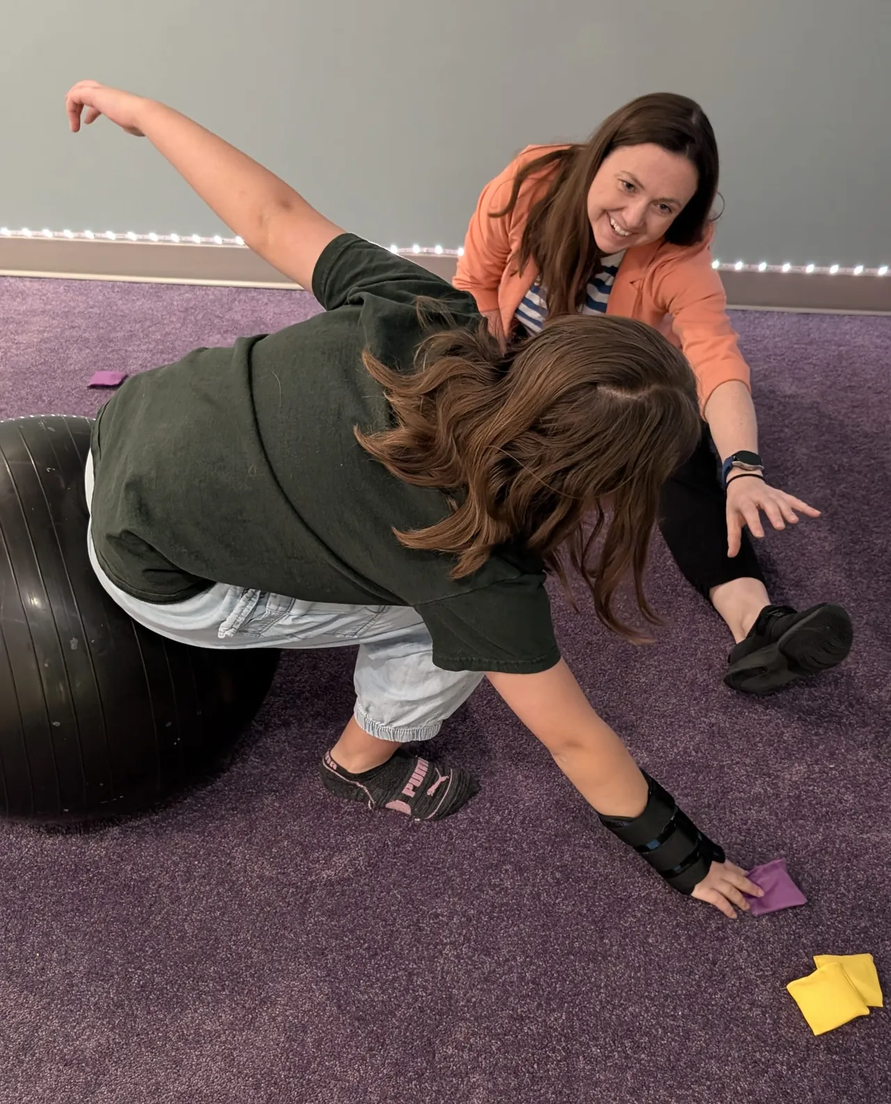 Heather supports a child through a movement activity during an occupational therapy assessment