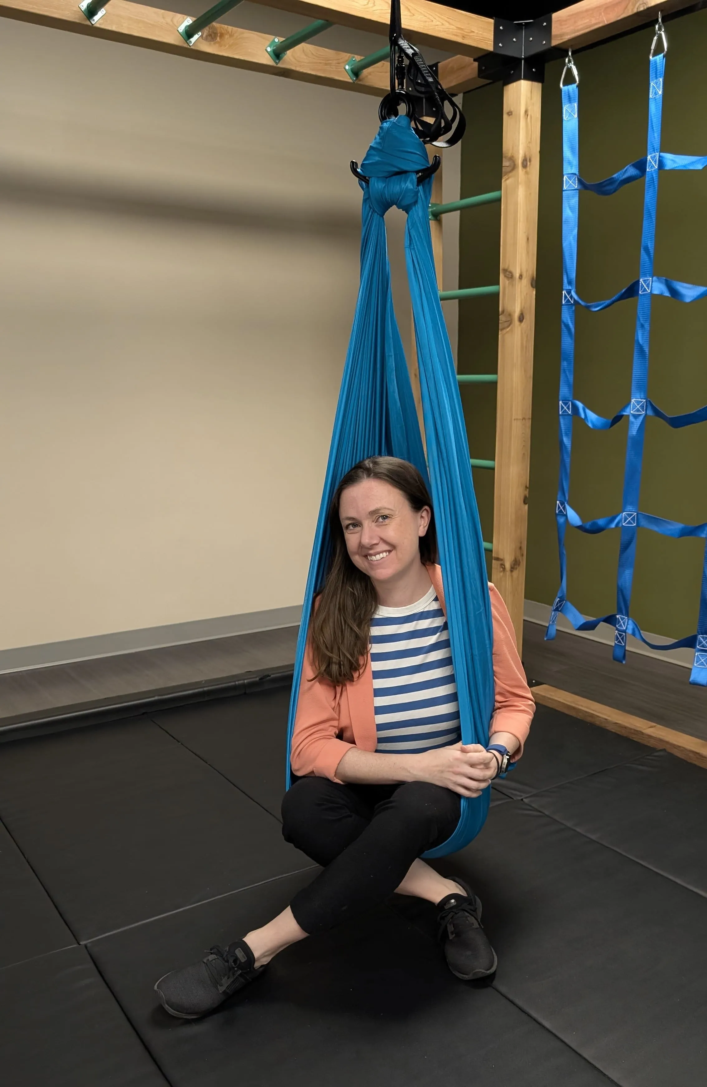 Heather hanging from playground equipment with a smile