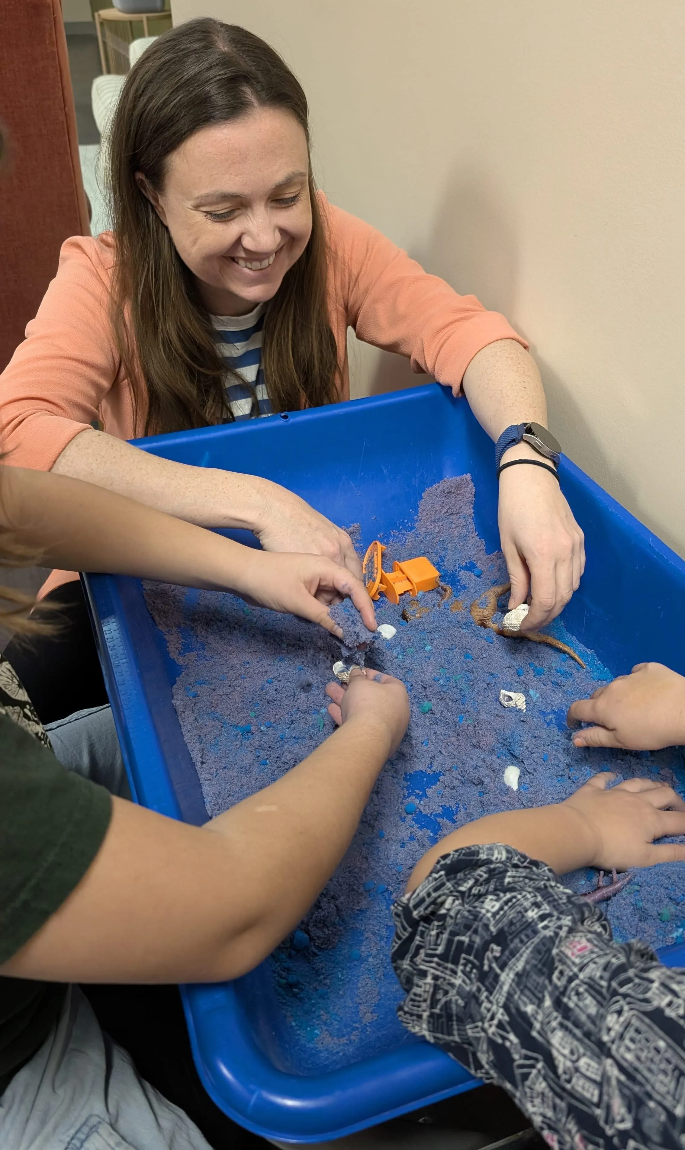 A child using a sand table during a sensory-focused therapy activity